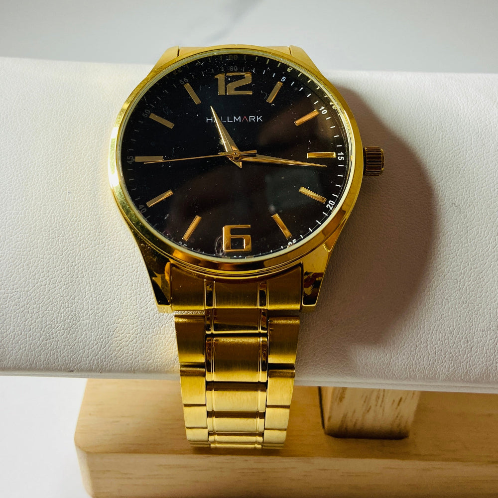 Gold wristwatch with black dial on a white cushion Gold wristwatch with black dial on a white cushion against a light background Gold Hallmark Watch watches mens kings DSJ Deep Shine Jewellers timeless timepiece time exclusive jewellery jewelry Your Time To Shine