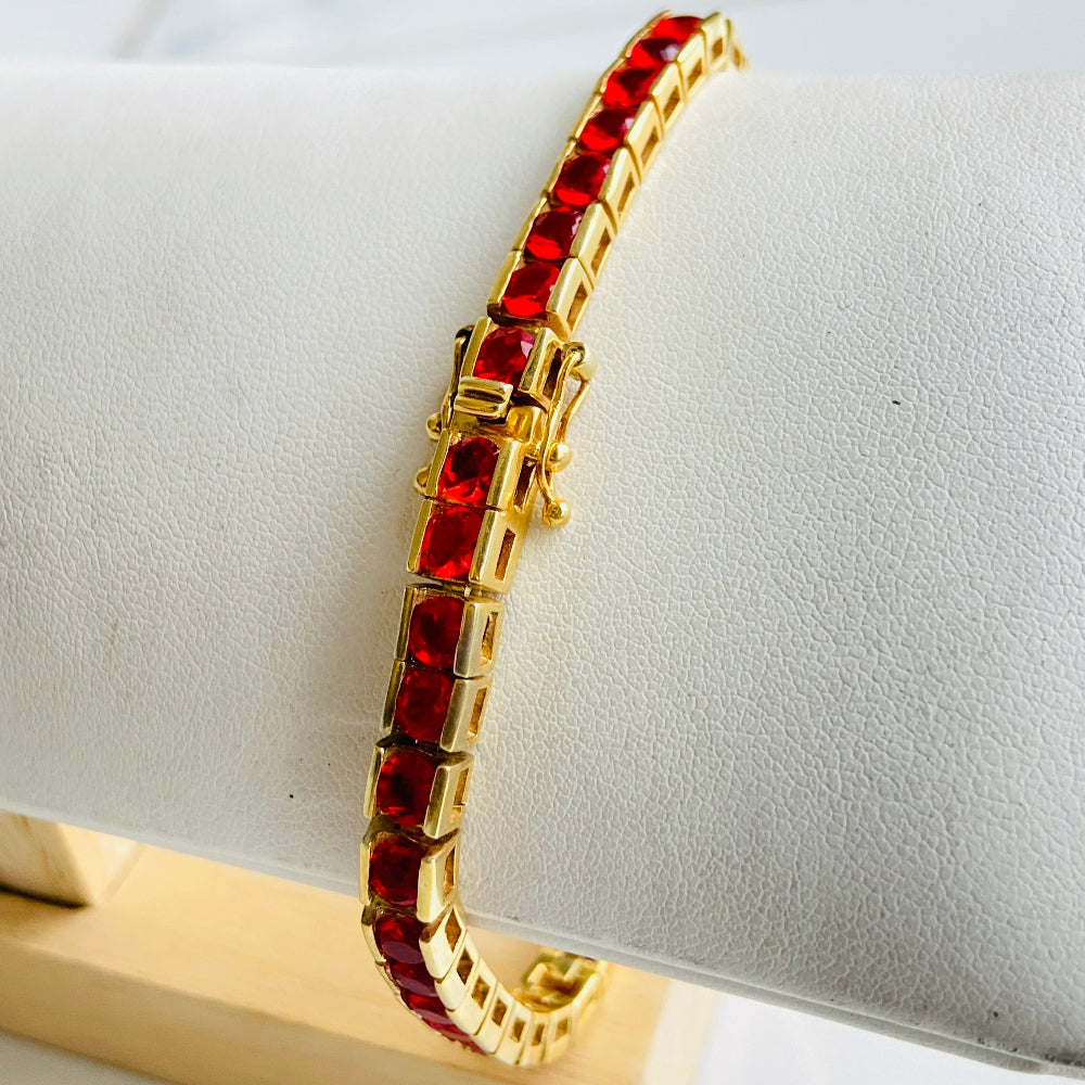 Gold bracelet with red gemstones on a white cushion Gold red ruby bracelet women queens ladies female tennis bracelet ruby red 925 silver sterling silver gold plated golden exclusive affordable luxury jewellery jewelry Deep Shine Jewellers DSJ Your Time To Shine trending best seller buy purchase bracelets 