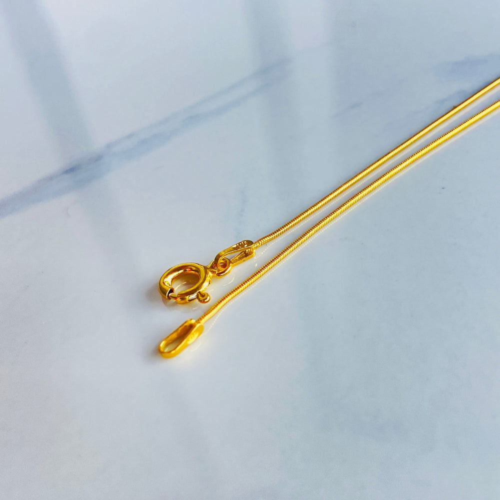 Gold bar on a light blue marble surface gold snake bone chain women men ladies gents kinds queens exclusive craftsmanship affordable luxury high quality premium jewellery jewelry Deep Shine Jewellers gold plated golden 925 silver sterling silver Your Time To Shine DSJ