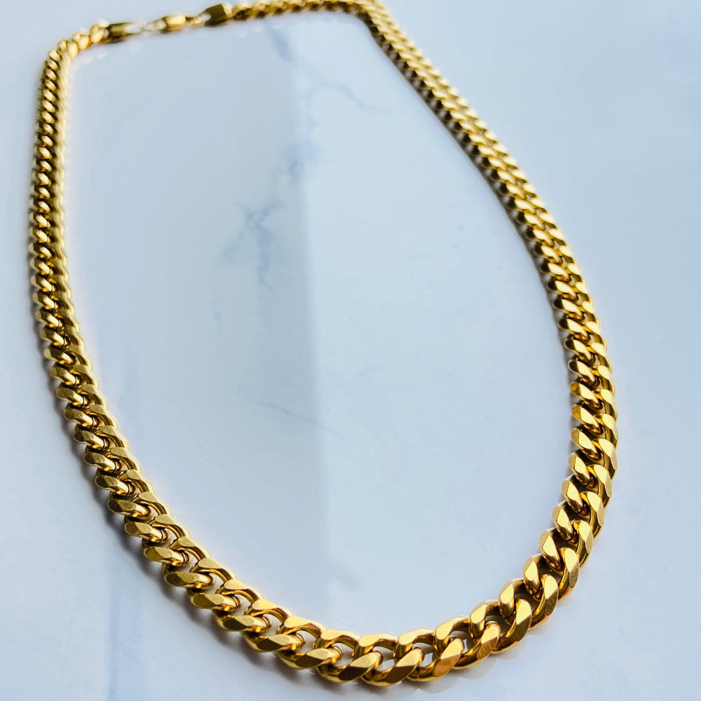 Gold chain necklace on a light gray background gold curb chain men women ladies gents kings queens stainless steel gold plated golden exclusive affordable luxury cuban link Deep Shine Jewellers jewellery jewelry Your Time To Shine DSJ trending premium accessories fashion