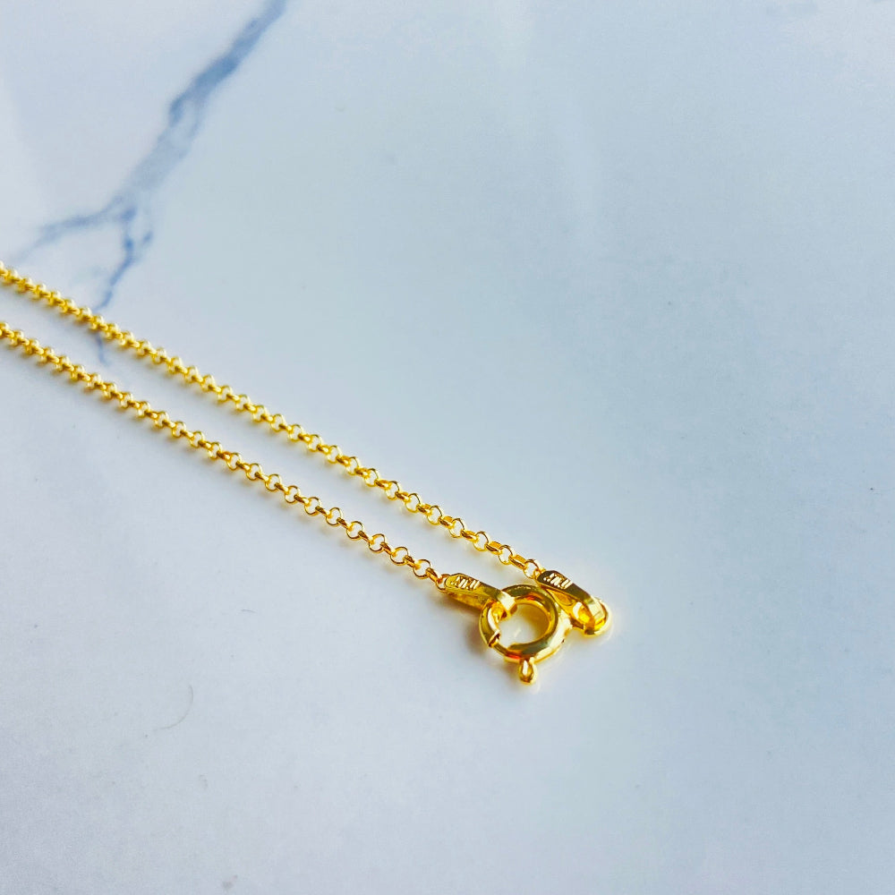 Gold necklace with a small pendant on a marble surface Gold chain necklace on a light gray textured background gold belcher chain women ladies queens gold plated golden 925 silver sterling silver affordable luxury premium jewelllery jewelry high quality trending shop now best selling Deep Shine Jewellers Your Time To Shine DSJ store 
