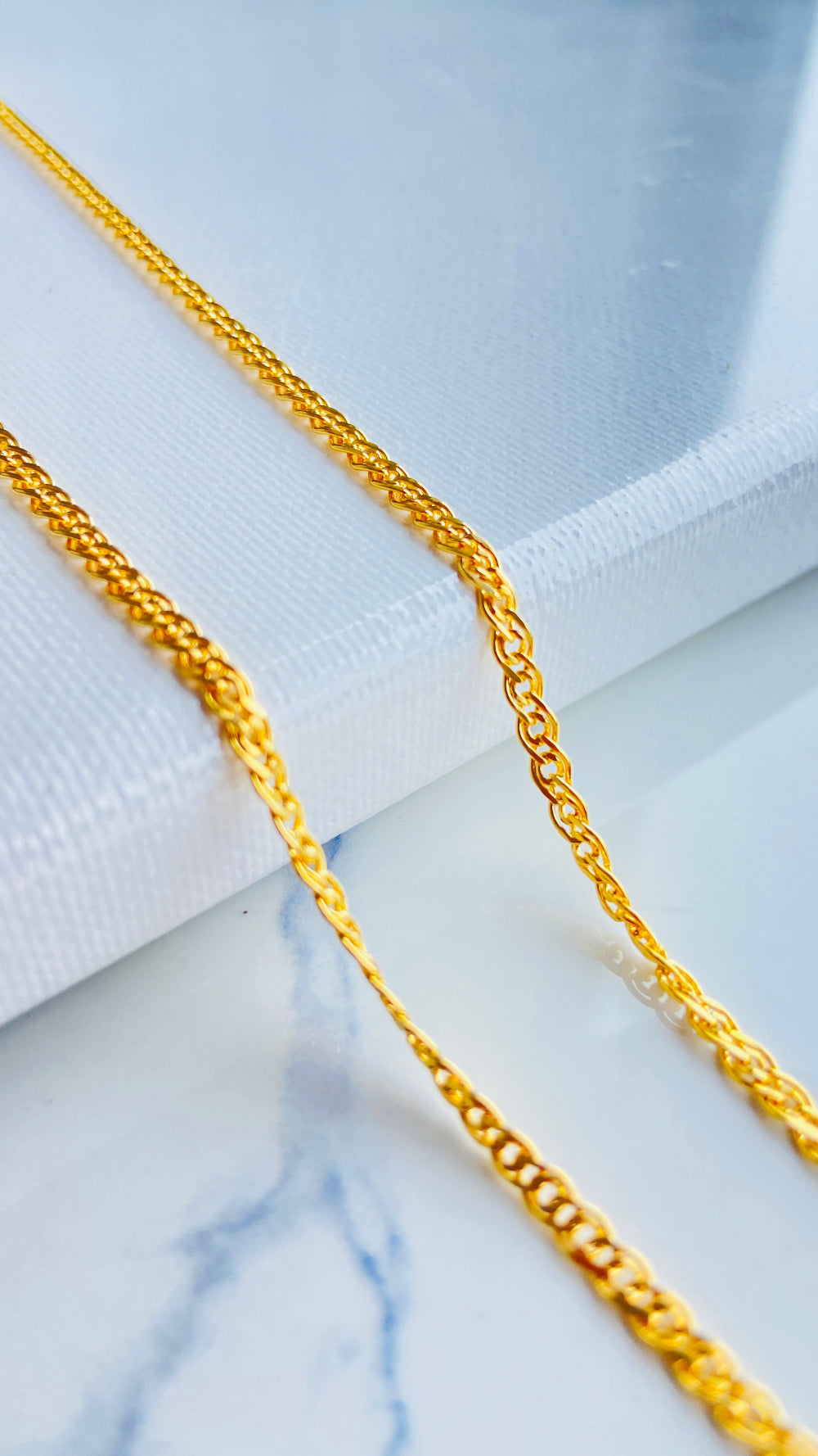 Gold chain on a marble surface Gold chain necklace on a light blue background gold fancy chain necklace women ladies queen 925 silver sterling silver gold plate golden best seller trending buy now premium jewellery jewelry high quality exclusive craftsmanship Deep Shine Jewellers DSJ Your Time To Shine online store 