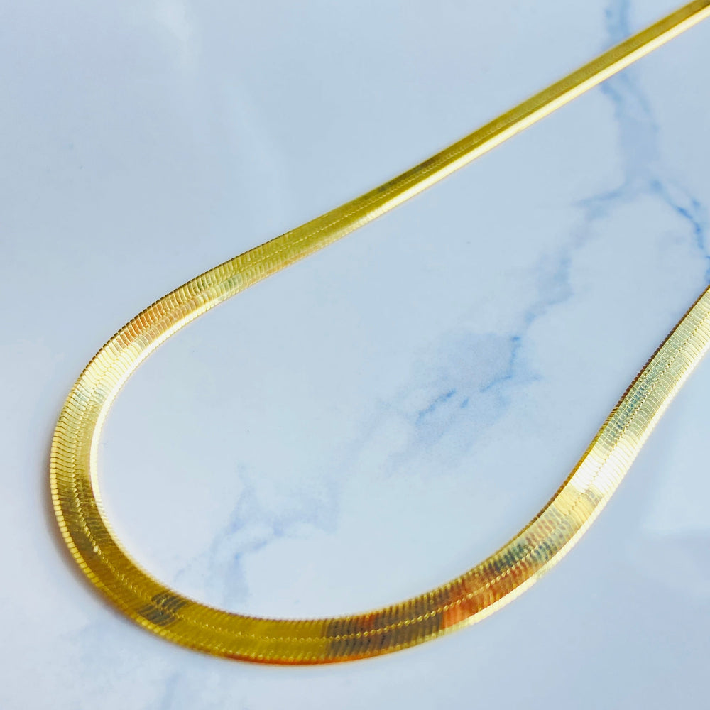 Gold hair clip on a marble background gold herringbone chain necklace women ladies queens 925 silver sterling silver premium jewellery jewelry affordable luxury exclusive craftsmanship Deep Shine Jewellers DSJ Your Time To Shine best seller trending shop now store million