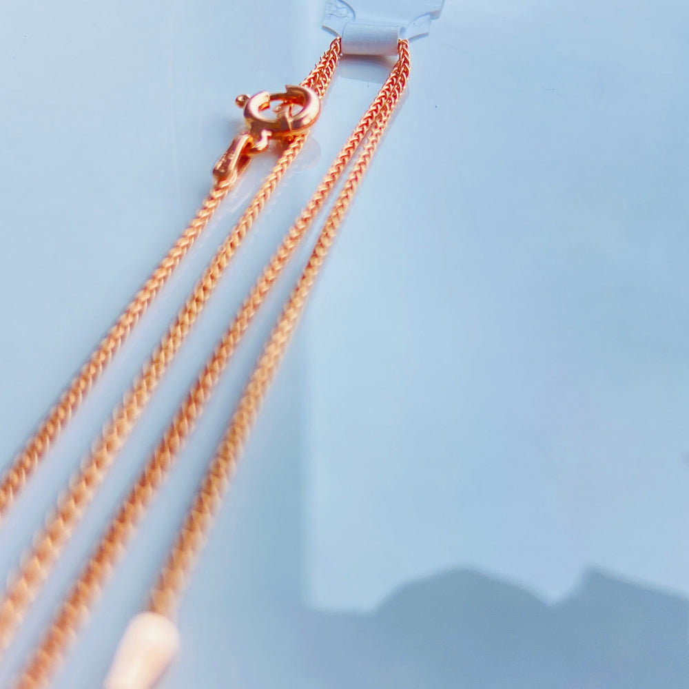 Rose gold necklace with a pink pendant on a light blue background Rose gold necklace on a light blue marble surface rose gold wheat chain necklace women ladies queens 925 silver sterling silver rose gold plating roses premium jewellery jewelry affordable luxury elegant best seller trending Deep Shine Jewellers DSJ Your Time To Shine