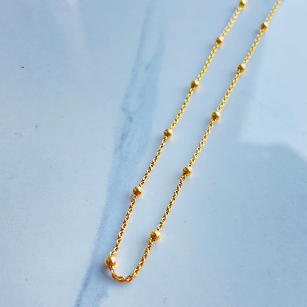 Gold necklace on a marble surface Gold chain necklace on a marble surface Gold ball linked cable chain necklaces women ladies queen gold plated golden 925 silver sterling silver premium jewellery jewelry affordable luxury best selling trending beauty Deep Shine Jewellery DSJ Your Time To Shine Cape Town exclusive craftsmaship South Africa ball and cable link 