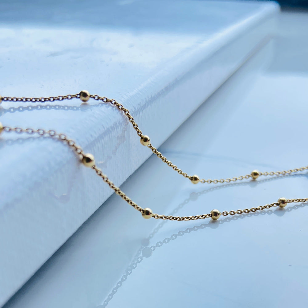 Gold necklace on a white surface Gold chain necklace on a marble surface Gold ball linked cable chain necklaces women ladies queen gold plated golden 925 silver sterling silver premium jewellery jewelry affordable luxury best selling trending beauty Deep Shine Jewellery DSJ Your Time To Shine Cape Town exclusive craftsmaship South Africa ball and cable link 