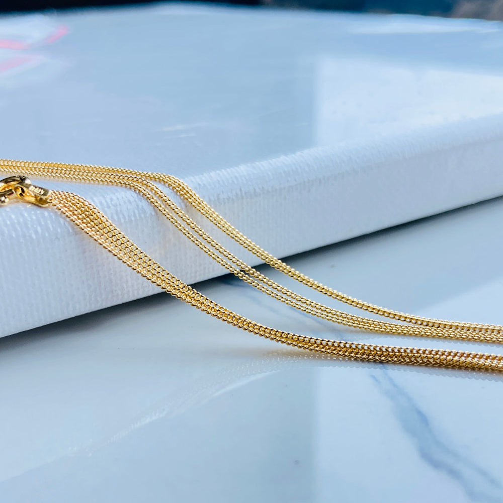 Gold chain necklace on a light gray surface Gold chain on a light blue background gold micro flat curb chain necklace gold plated golden 925 silver sterling silver precious metals premium jewellery jewelry affordable luxury women mens gents ladies queens kings exclusive craftsmanship Deep Shine Jewellery DSJ Your Time To Shine trending best sellers kingdom