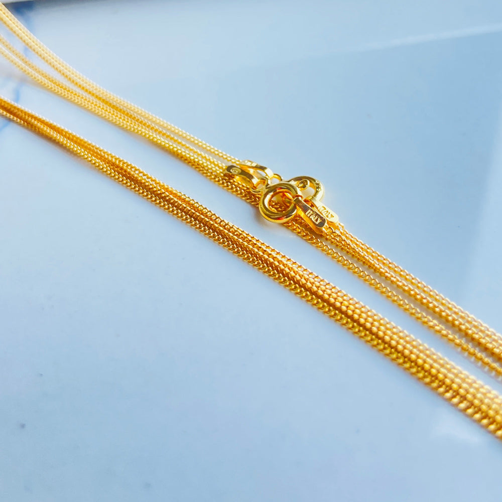 Gold chain necklace on a light blue surface Gold chain on a light blue background gold micro flat curb chain necklace gold plated golden 925 silver sterling silver precious metals premium jewellery jewelry affordable luxury women mens gents ladies queens kings exclusive craftsmanship Deep Shine Jewellery DSJ Your Time To Shine trending best sellers kingdom