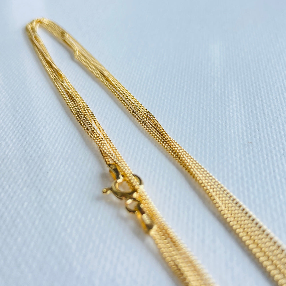 Gold necklace on a light gray background Gold chain on a light blue background gold micro flat curb chain necklace gold plated golden 925 silver sterling silver precious metals premium jewellery jewelry affordable luxury women mens gents ladies queens kings exclusive craftsmanship Deep Shine Jewellery DSJ Your Time To Shine trending best sellers kingdom