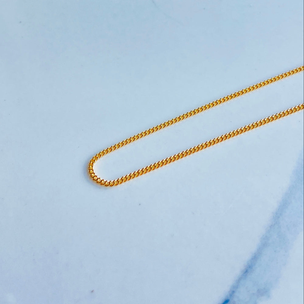 Gold chain on a light blue background gold micro flat curb chain necklace gold plated golden 925 silver sterling silver precious metals premium jewellery jewelry affordable luxury women mens gents ladies queens kings exclusive craftsmanship Deep Shine Jewellery DSJ Your Time To Shine trending best sellers kingdom