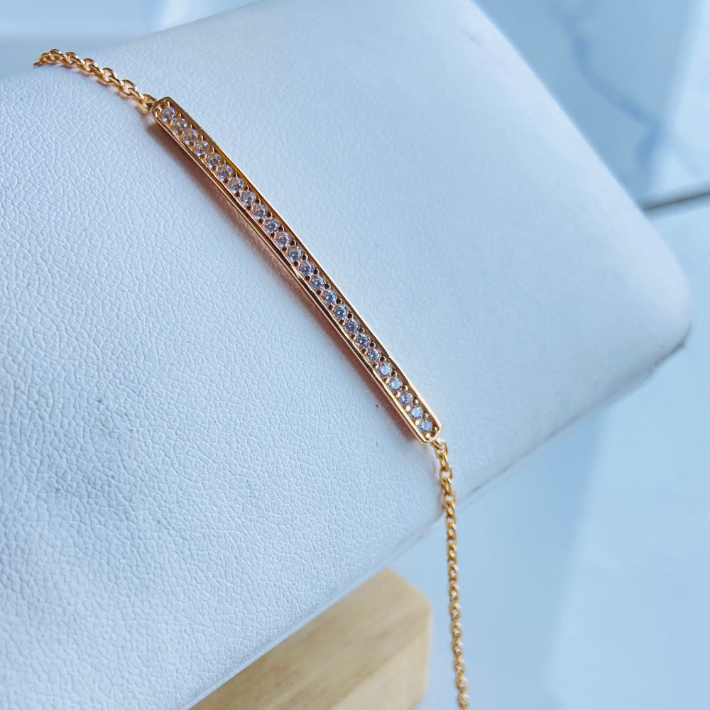 Gold bracelet on a light blue surface with a wooden stand Gold bracelet with small diamonds on a white fabric background rose gold ice strip bracelet women ladies queens 925 silver sterling premium jewellery jewelry affordable luxury Deep Shine Jewellers exclusive craftsmanship best sellers trending christmas gifts Your Time To Shine DSJ Cape Town rose gold plating 