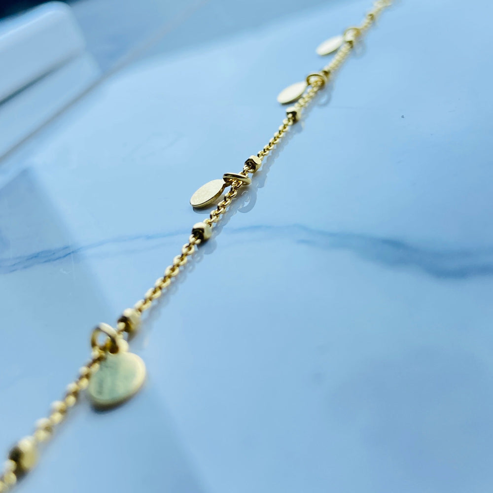 Gold bracelet with heart charm on a light blue background Gold chain bracelet on a light blue fabric background Shine Bright with Deep Shine Jewellers Exclusive Gold Circle and Chain Bracelet women ladies queens 925 silver sterling silver gold plated golden premium jewellery jewelry affordable luxury best sellers trending christmas gifts loved ones Your Time To Shine DSJ exclusive craftsmanship 