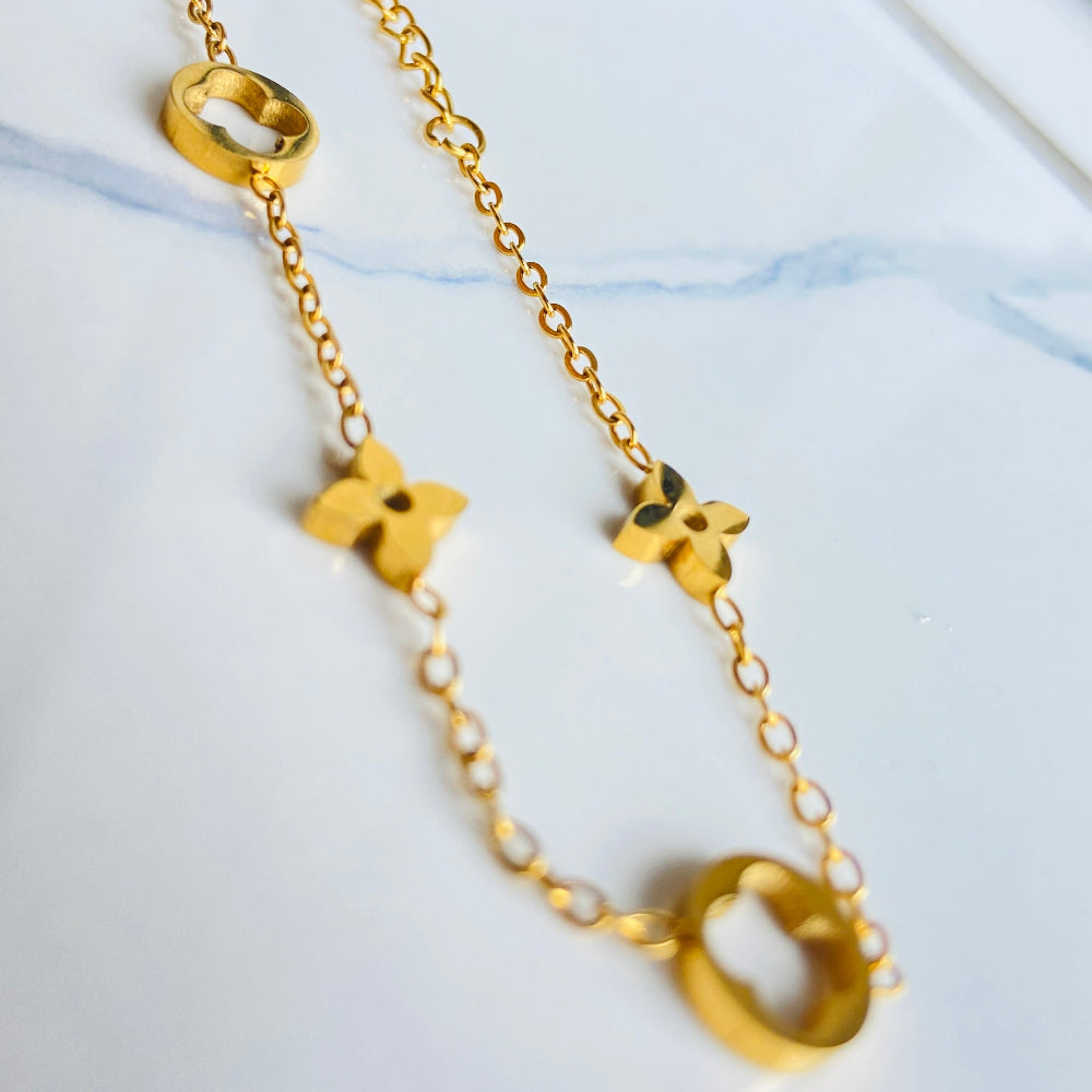 Gold bracelet with clover-shaped charms on a light blue background gold clover bracelet womens mens ladies gents queens kings van cleef and arpels charm gold plated golden premium jewellery jewelry exclusive craftsmanship cape town best sellers stainless steel trending modern classy Deep Shine Jewellers DSJ Your Time To Shine online store affordable luxury 