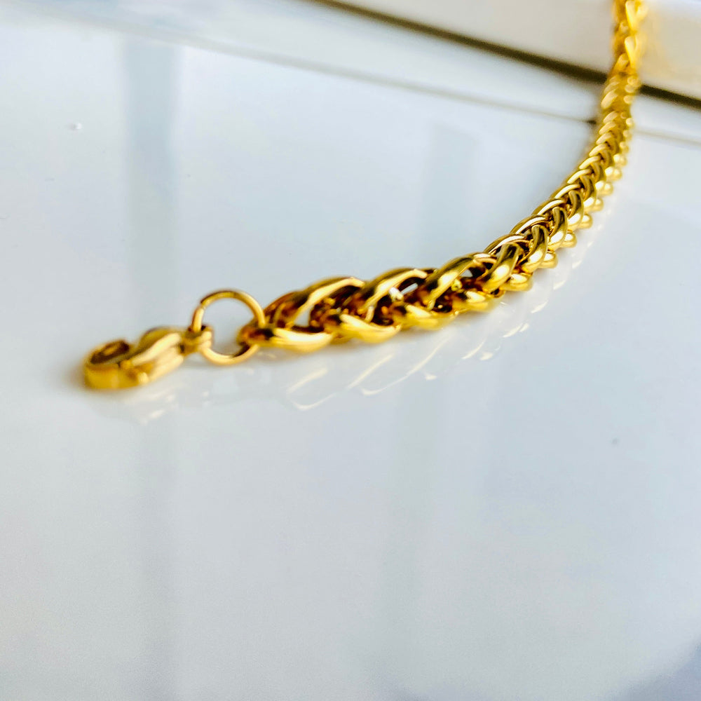 Gold chain bracelet on a light background Gold chain bracelet on a marble surface gold wheat bracelet womens mens ladies gents queens kings stainless steel gold plated golden exclusive craftsmanship affordable luxury premium jewellery jewelry cape town design Deep Shine Jewellers DSJ Your Time To Shine best sellers online store vault trending sales 