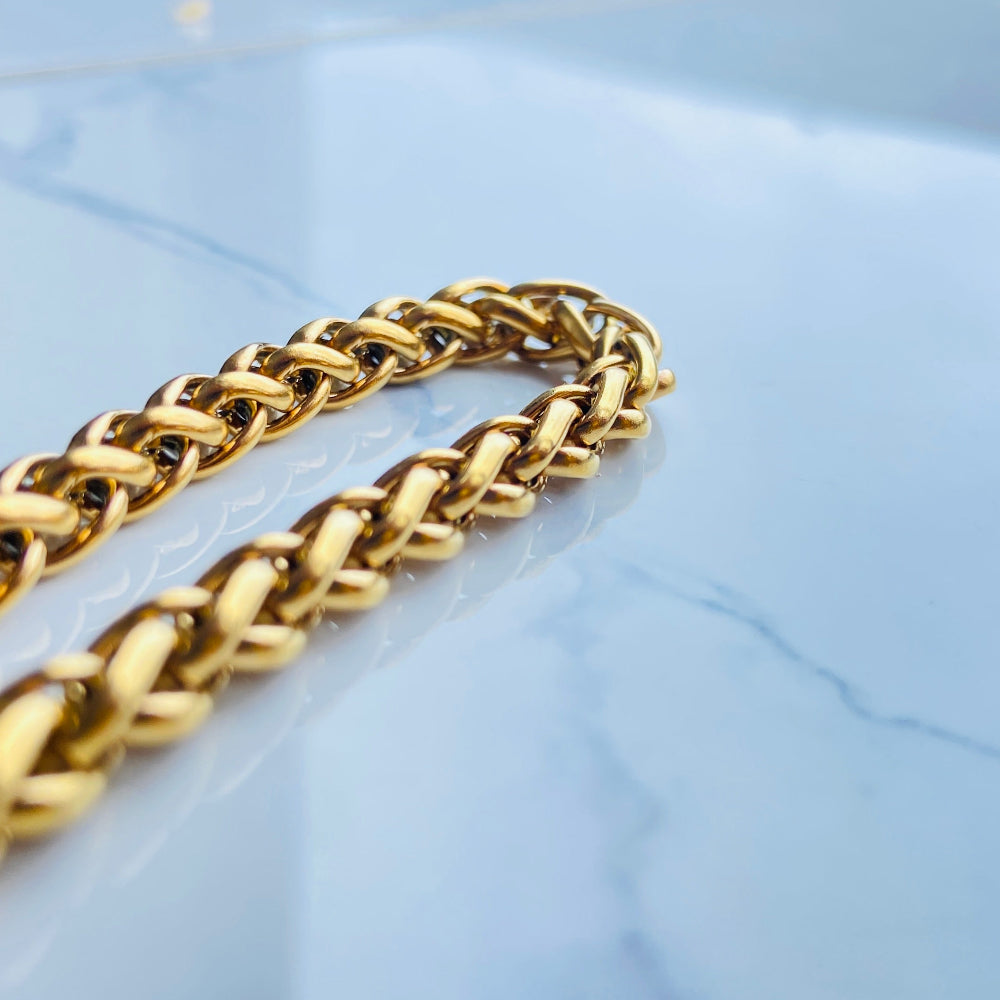 Gold chain on a light blue marble surface Gold chain bracelet on a marble surface gold wheat bracelet womens mens ladies gents queens kings stainless steel gold plated golden exclusive craftsmanship affordable luxury premium jewellery jewelry cape town design Deep Shine Jewellers DSJ Your Time To Shine best sellers online store vault trending sales 