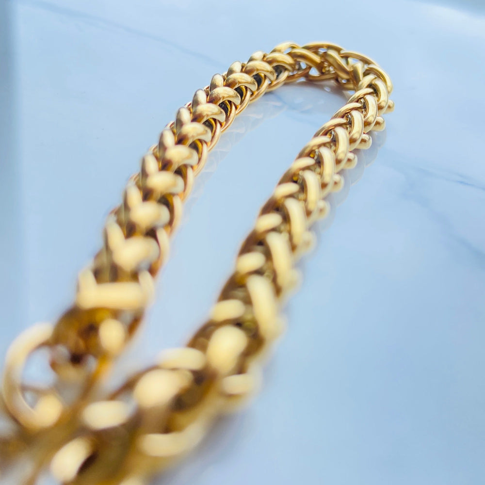 Gold chain on a light blue background Gold chain bracelet on a marble surface gold wheat bracelet womens mens ladies gents queens kings stainless steel gold plated golden exclusive craftsmanship affordable luxury premium jewellery jewelry cape town design Deep Shine Jewellers DSJ Your Time To Shine best sellers online store vault trending sales 