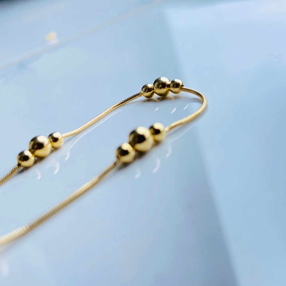 Gold beaded necklace on a light blue background gold ball and snake bracelet women ladies queens gold plated golden 925 silver sterling silver exclusive craftsmanship affordable luxury premium quality jewellery jewelry Deep Shine Jewellery DSJ Your Time To Shine best sellers trending chrismas sale gifts 