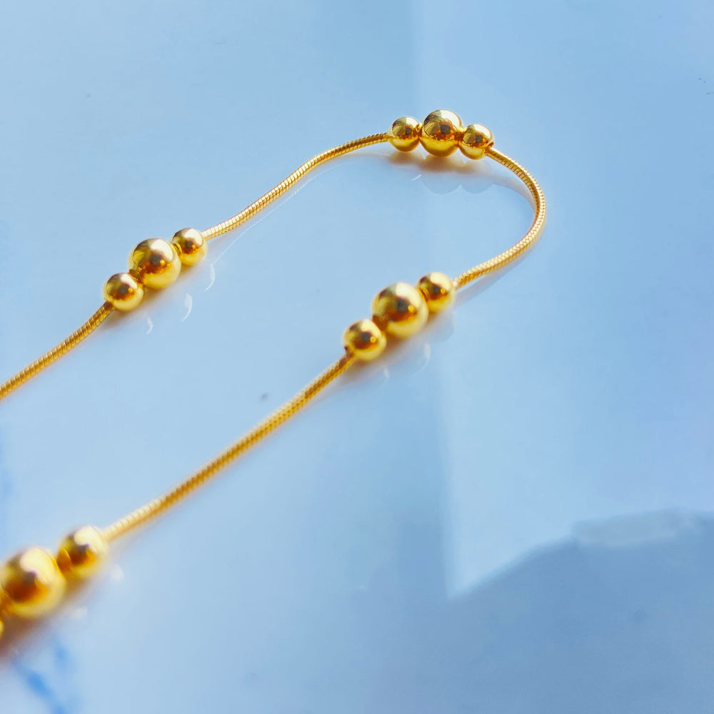 Gold beaded necklace on a light blue background gold ball and snake bracelet women ladies queens gold plated golden 925 silver sterling silver exclusive craftsmanship affordable luxury premium quality jewellery jewelry Deep Shine Jewellery DSJ Your Time To Shine best sellers trending chrismas sale gifts 