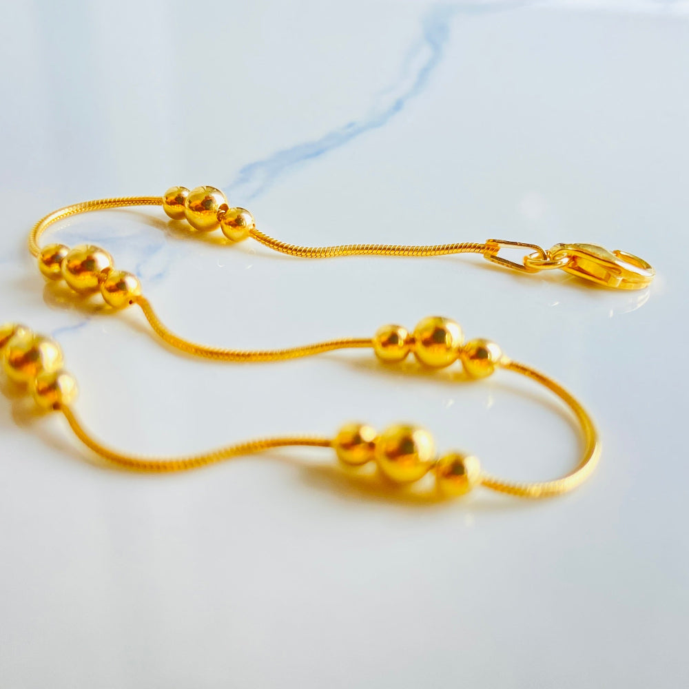 Gold necklace on a white surface Gold beaded necklace on a light blue background gold ball and snake bracelet women ladies queens gold plated golden 925 silver sterling silver exclusive craftsmanship affordable luxury premium quality jewellery jewelry Deep Shine Jewellery DSJ Your Time To Shine best sellers trending chrismas sale gifts 