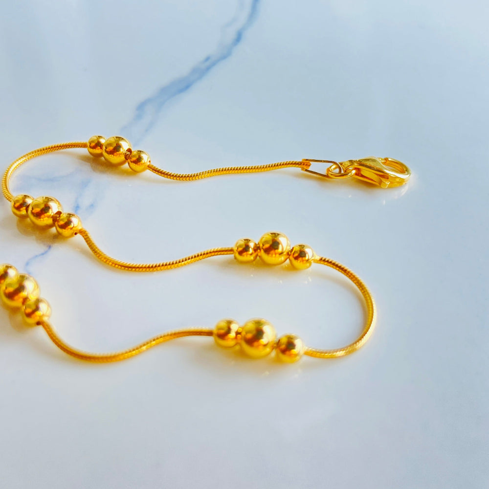 Gold necklace on a marble surface Gold beaded necklace on a light blue background gold ball and snake bracelet women ladies queens gold plated golden 925 silver sterling silver exclusive craftsmanship affordable luxury premium quality jewellery jewelry Deep Shine Jewellery DSJ Your Time To Shine best sellers trending chrismas sale gifts 