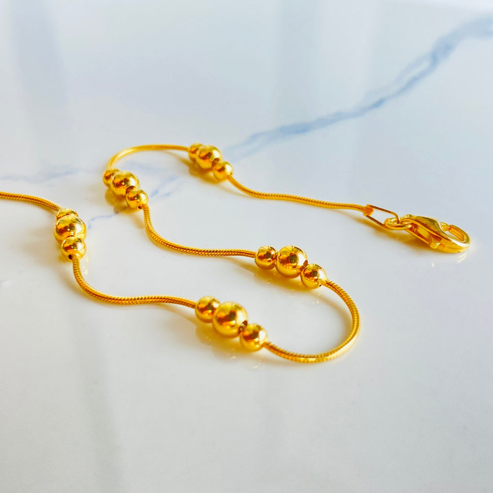 Gold necklace on a white fabric background Gold beaded necklace on a light blue background gold ball and snake bracelet women ladies queens gold plated golden 925 silver sterling silver exclusive craftsmanship affordable luxury premium quality jewellery jewelry Deep Shine Jewellery DSJ Your Time To Shine best sellers trending chrismas sale gifts 