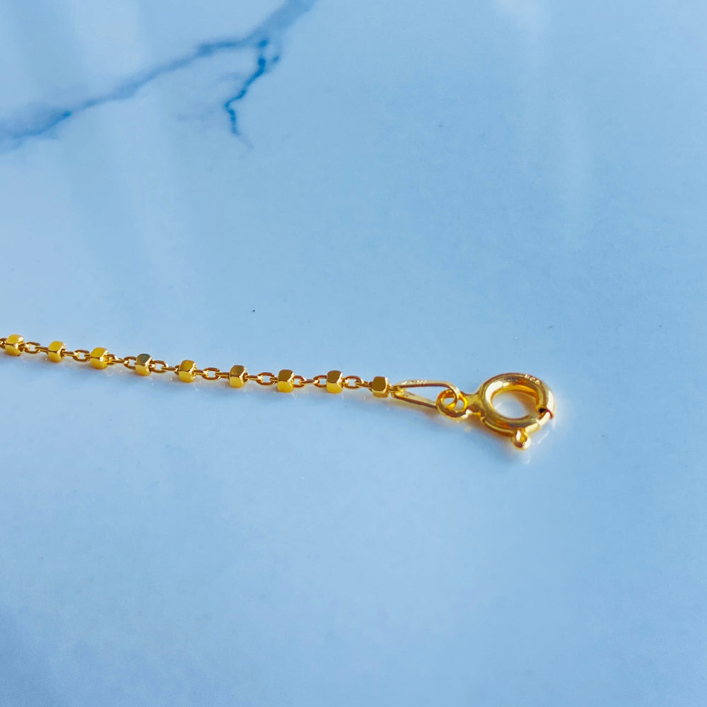 Gold chain on a light blue marble surface gold block bead bracelet women ladies queens gold plated golden 925 silver sterling silver buy now exclusive craftsmanship affordable luxury best sellers trending beauty premium quality jewellery jewelry Deep Shine Jewellers Your Time To Shine DSJ shop now 