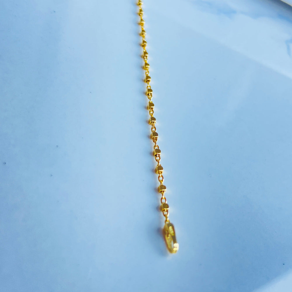 Gold necklace with a small pendant on a light blue background Gold chain on a light blue marble surface gold block bead bracelet women ladies queens gold plated golden 925 silver sterling silver buy now exclusive craftsmanship affordable luxury best sellers trending beauty premium quality jewellery jewelry Deep Shine Jewellers Your Time To Shine DSJ shop now 