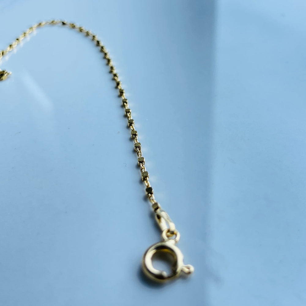 Gold necklace chain on a reflective surface Gold chain on a light blue marble surface gold block bead bracelet women ladies queens gold plated golden 925 silver sterling silver buy now exclusive craftsmanship affordable luxury best sellers trending beauty premium quality jewellery jewelry Deep Shine Jewellers Your Time To Shine DSJ shop now 