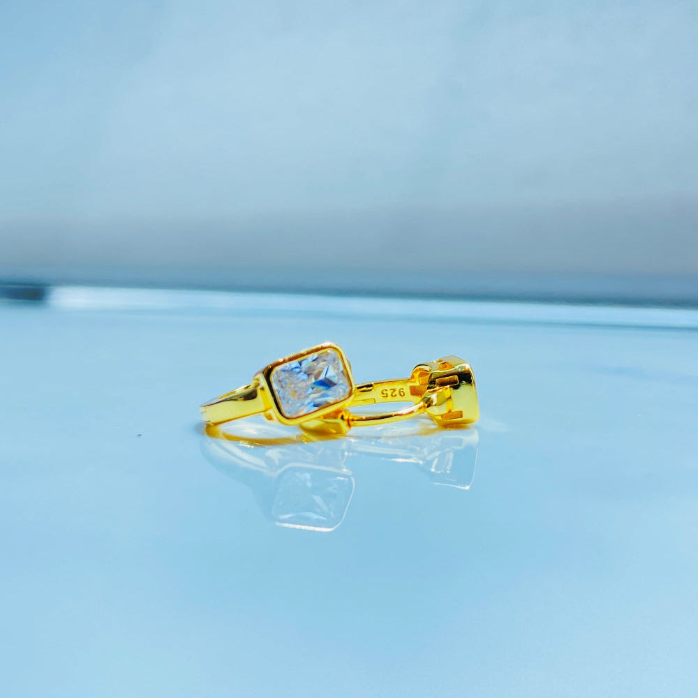 Gold ring with a clear gemstone on a light blue background Gold hoop earring with clear stones on a reflective surface with blue sky background gold single stone sleeper earrings women ladies queens gold plated golden cubic zirconia diamond baguette 925 silver sterling silver exclusive craftsmanship high quality premium affordable luxury Deep Shine Jewellers jewellery jewelry Your Time To Shine DSJ