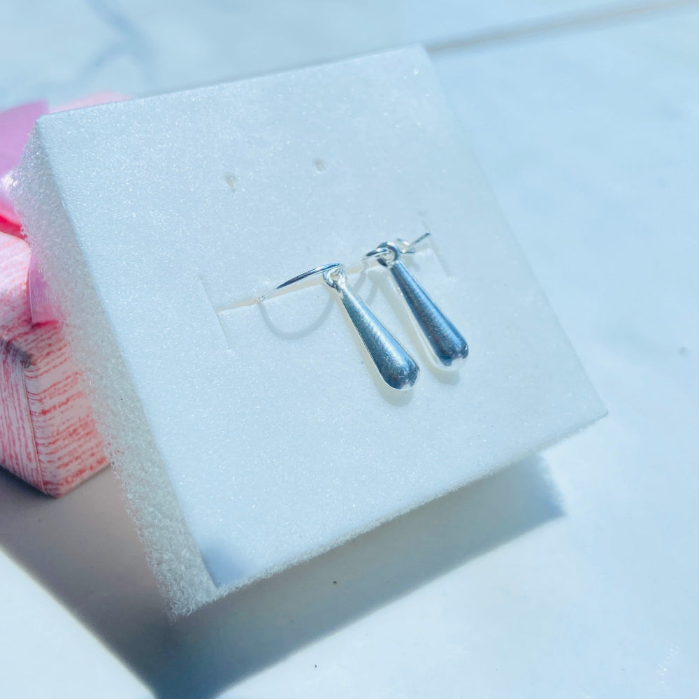 Pair of earrings on a white card with a blurred background silver teardrop earrings women ladies queens 925 silver sterling silver exclusive craftsmanship Deep Shine Jewellers jewellery jewelry dangle drop trending best seller shine bright Your Time To Shine DSJ