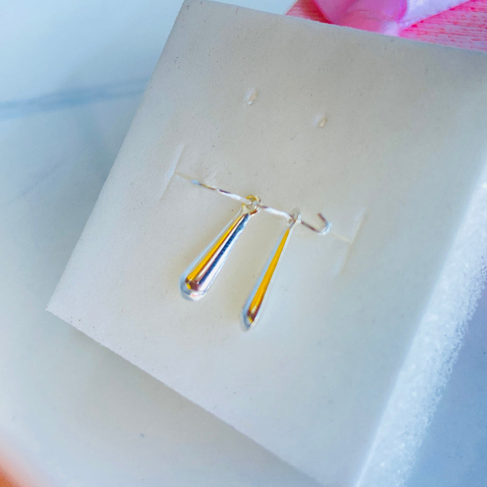 Small earring on a white card with a blurred background Pair of earrings on a white card with a blurred background silver teardrop earrings women ladies queens 925 silver sterling silver exclusive craftsmanship Deep Shine Jewellers jewellery jewelry dangle drop trending best seller shine bright Your Time To Shine DSJ