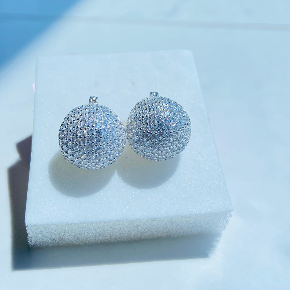 Silver spherical earrings on a white stand with a blurred background Silver earrings on a white stand with a blurred outdoor background silver ice dome earrings women ladies queens 925 silver sterling silver cubic zirconia diamonds lab diamonds affordable luxury exclusive craftsmanship Deep Shine Jewellers jewellery jewelry DSJ Your Time To Shine limited premium jewellery trending