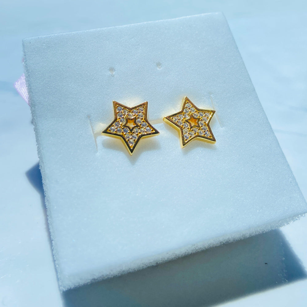 Gold star-shaped earrings on a white jewelry box with a scenic background Gold star-shaped earrings on a white box with a scenic background gold iced star stud earring women men ladies gents kings queens 925 silver sterling silver gold plated golden shine exclusive craftsmanship Deep Shine Jewellers Jewellery jewelry trending shop now store bright beauty 