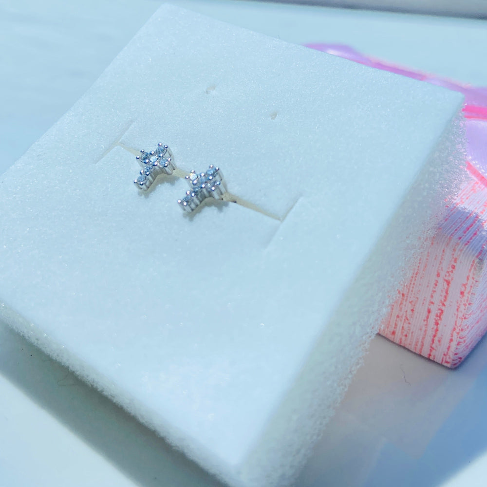Diamond stud earrings in a white jewelry box with a blurred background Silver earrings on a white card with a pink bow in the background silver ice cross stud earring women men ladies gents queens kings 925 silver sterling silver exclusive affordable luxury jewellery jewelry Deep Shine Jewellers trending. shop now best sellers elegant DSJ Your Time To Shine