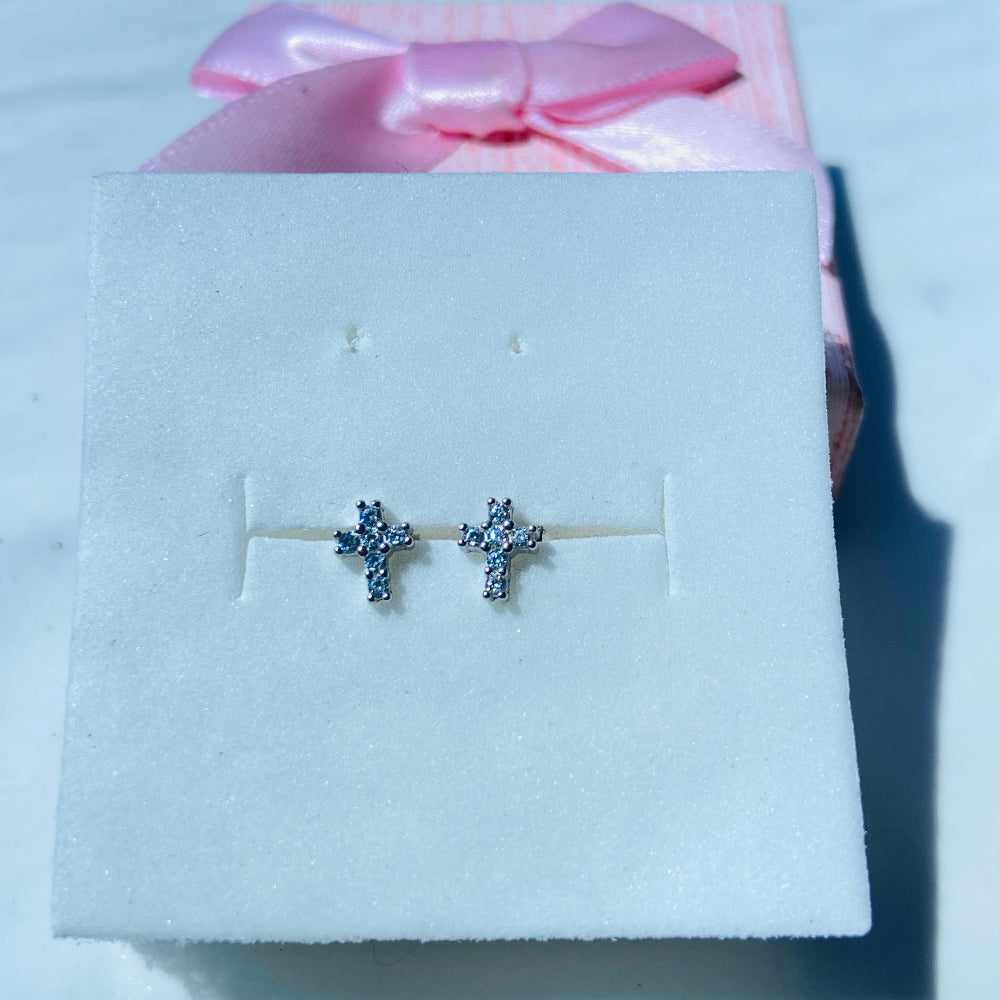 Silver earrings on a white card with a pink bow in the background silver ice cross stud earring women men ladies gents queens kings 925 silver sterling silver exclusive affordable luxury jewellery jewelry Deep Shine Jewellers trending. shop now best sellers elegant DSJ Your Time To Shine