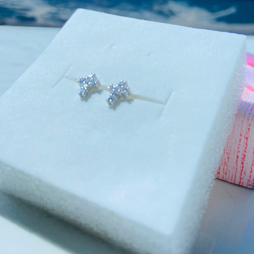 Silver earrings on a white card with a pink bow in the background silver ice cross stud earring women men ladies gents queens kings 925 silver sterling silver exclusive affordable luxury jewellery jewelry Deep Shine Jewellers trending. shop now best sellers elegant DSJ Your Time To Shine