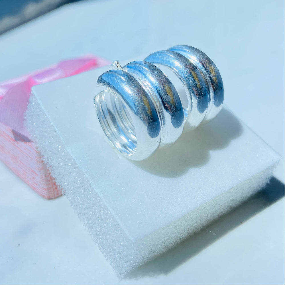 Silver spiral earring on a white stand with a blurred background silver double hoop earrings women ladies queens 925 silver sterling silver exclusive affordable luxury jewellery jewelry Deep Shine Jewellers trending style accessories Your Time To Shine gift christmas DSJ 