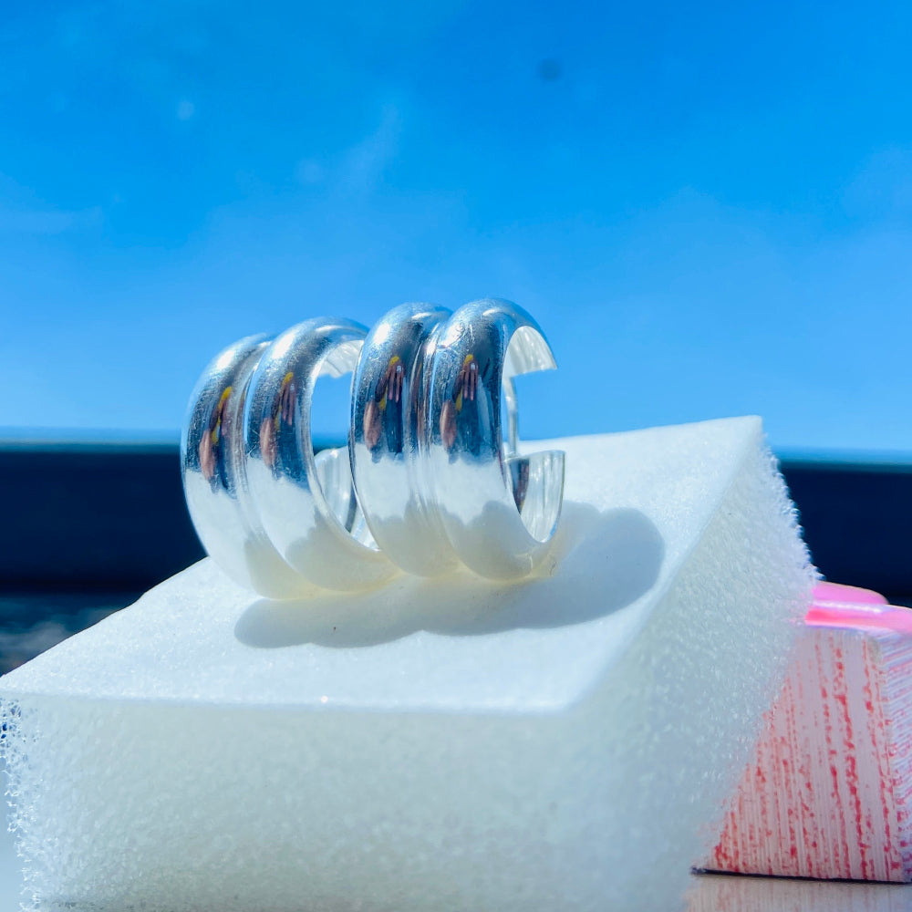 Silver spiral ring on a white stand with a blue sky background Silver spiral earring on a white stand with a blurred background silver double hoop earrings women ladies queens 925 silver sterling silver exclusive affordable luxury jewellery jewelry Deep Shine Jewellers trending style accessories Your Time To Shine gift christmas DSJ 