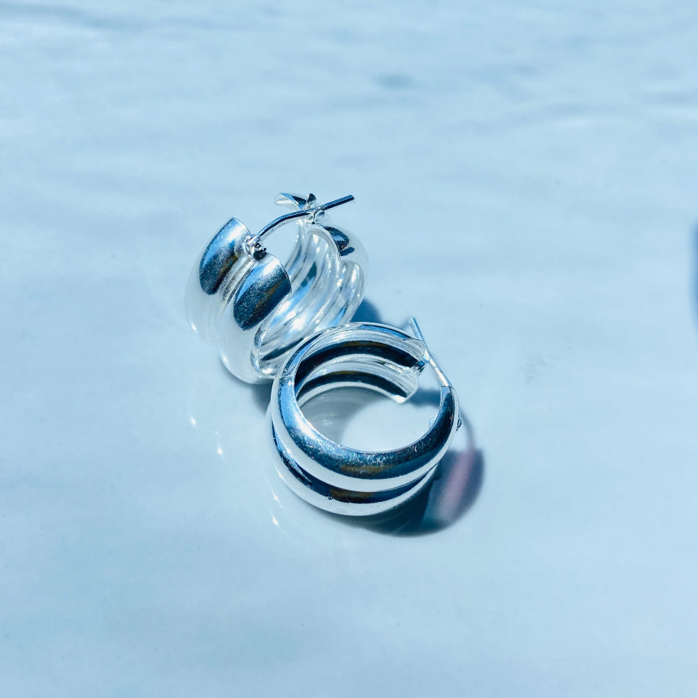 Silver hoop earrings with black stripes on a light blue background Silver spiral earring on a white stand with a blurred background silver double hoop earrings women ladies queens 925 silver sterling silver exclusive affordable luxury jewellery jewelry Deep Shine Jewellers trending style accessories Your Time To Shine gift christmas DSJ 