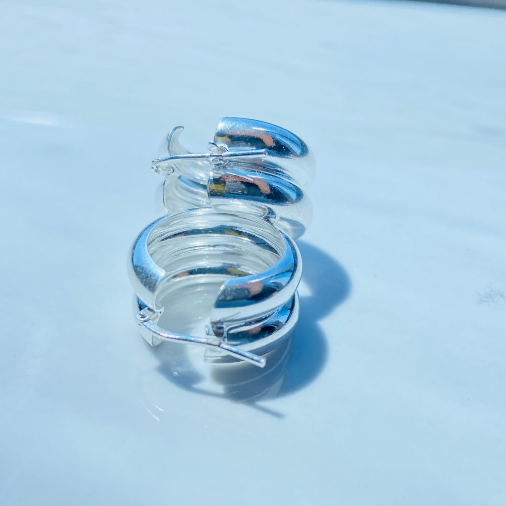 Silver spiral ring on a light blue surface with a blurred background Silver spiral earring on a white stand with a blurred background silver double hoop earrings women ladies queens 925 silver sterling silver exclusive affordable luxury jewellery jewelry Deep Shine Jewellers trending style accessories Your Time To Shine gift christmas DSJ 