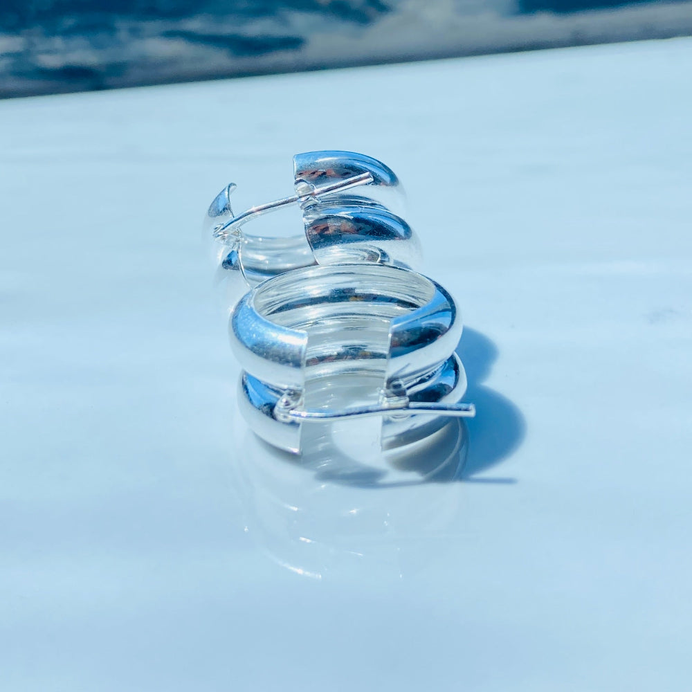 Silver spiral earring on a white stand with a blurred background silver double hoop earrings women ladies queens 925 silver sterling silver exclusive affordable luxury jewellery jewelry Deep Shine Jewellers trending style accessories Your Time To Shine gift christmas DSJ 