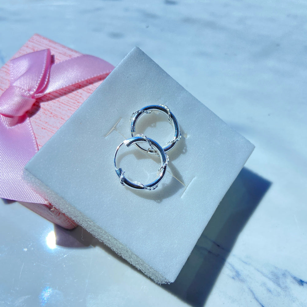 Silver hoop earrings on a white box with a pink ribbon silver twisted sleeper hoop earrings for men women ladies gents queens kings 925 silver sterling silver premium quality exclusive craftsmanship Deep Shine Jewellers jewellery jewelry affordable luxury Your Time To Shine DSJ