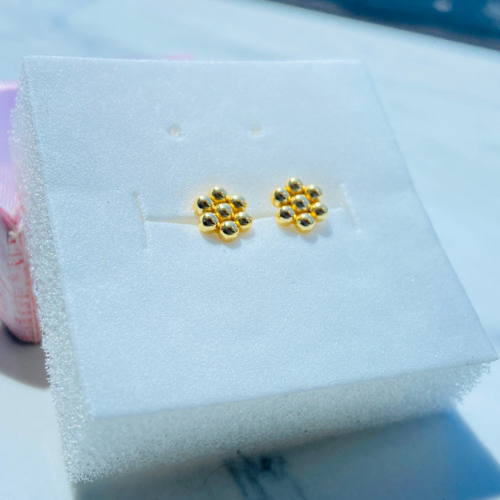 Gold flower-shaped earrings on a white cushion with a blue background Gold earrings with gemstones on a white stand against a blue background gold round bee hive earring for men women ladies gents kings queens 925 silver sterling silver gold plated golden exclusive craftsmanship Deep Shine Jewellers jewellery jewelry Your Time To Shine DSJ Trending Shop now