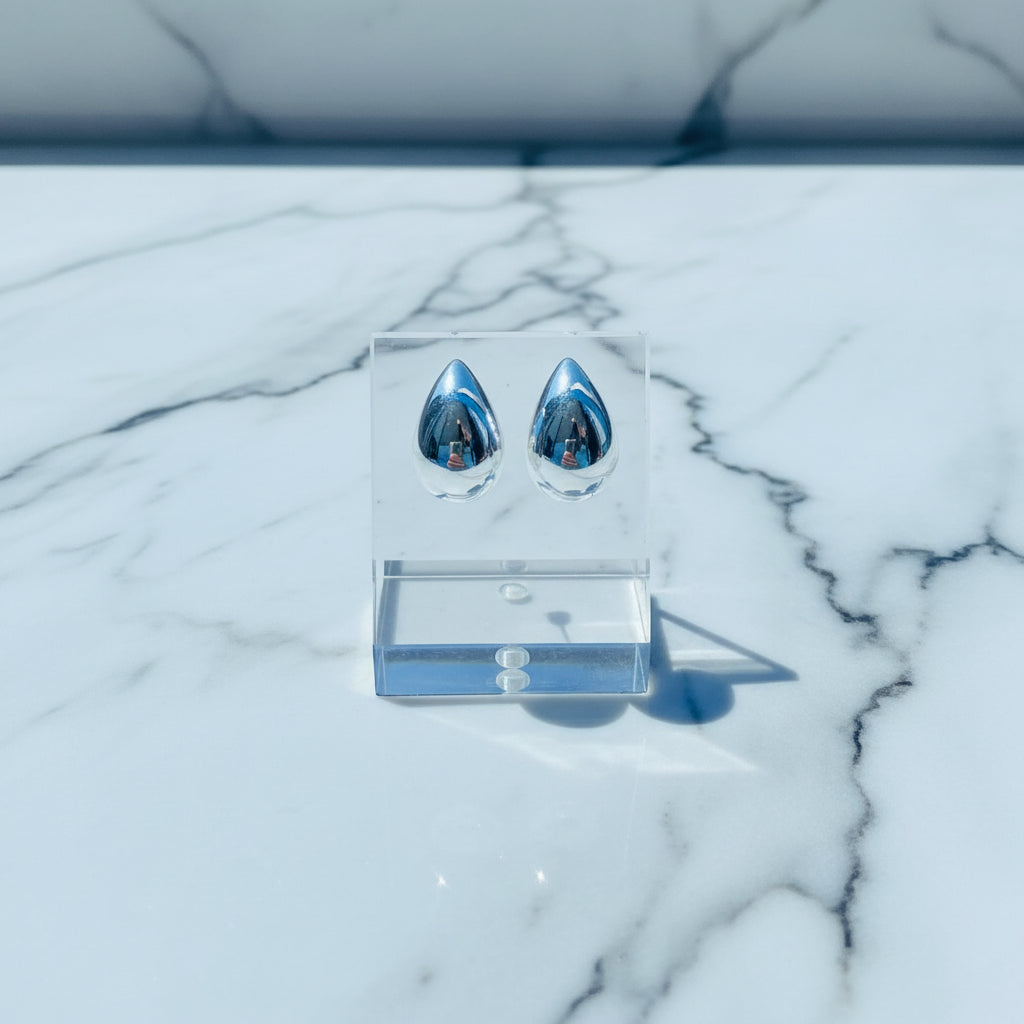 Silver earrings on a white stand with a blurred outdoor background silver drop form earrings for women ladies queens silver 925 silver sterling silver exclusive jewellery jewelry by Deep Shine Jewellers Your Time To Shine DSJ shinning beauty