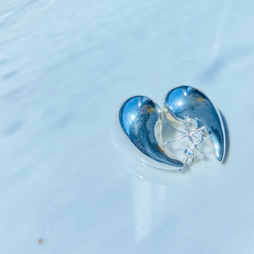 Clear earbuds with blue accents on a light blue surface silver drop form earrings for women ladies queens silver 925 silver sterling silver exclusive jewellery jewelry by Deep Shine Jewellers Your Time To Shine DSJ shinning beauty