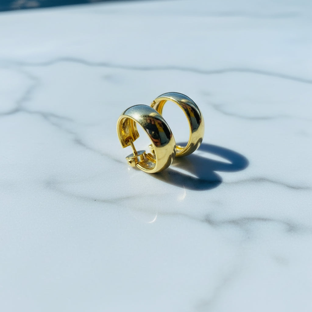 Gold ring on a white surface with a blue background thick gold sleeper hoop earrings women ladies queens exclusive affordable luxury Deep Shine Jewellers jewellery jewelry gold plated 925 silver sterling silver Your Time To Shine DSJ craftsmanship trending shop now