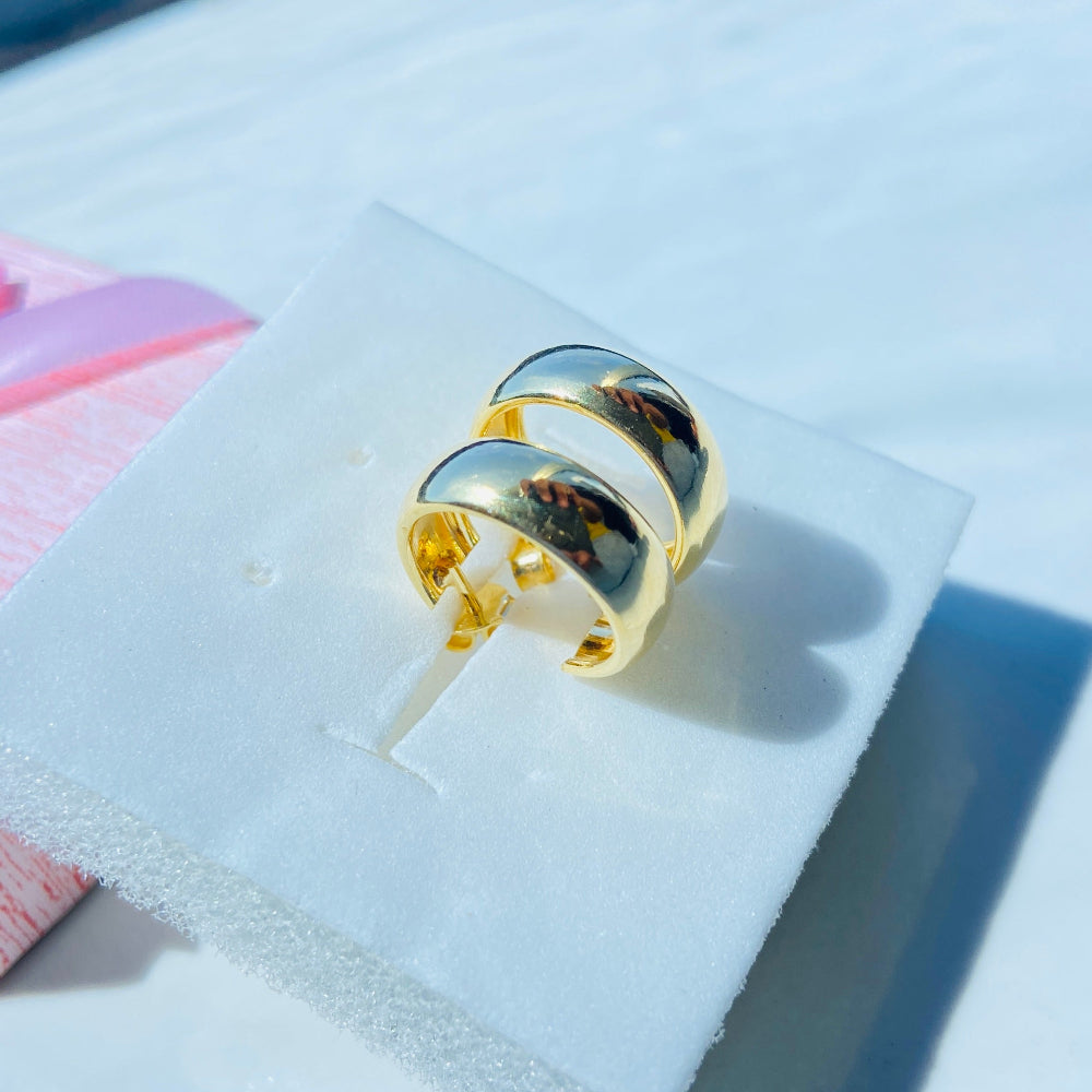 Gold ring on a clear stand with a blue and white background Gold ring on a white surface with a blue background thick gold sleeper hoop earrings women ladies queens exclusive affordable luxury Deep Shine Jewellers jewellery jewelry gold plated 925 silver sterling silver Your Time To Shine DSJ craftsmanship trending shop now