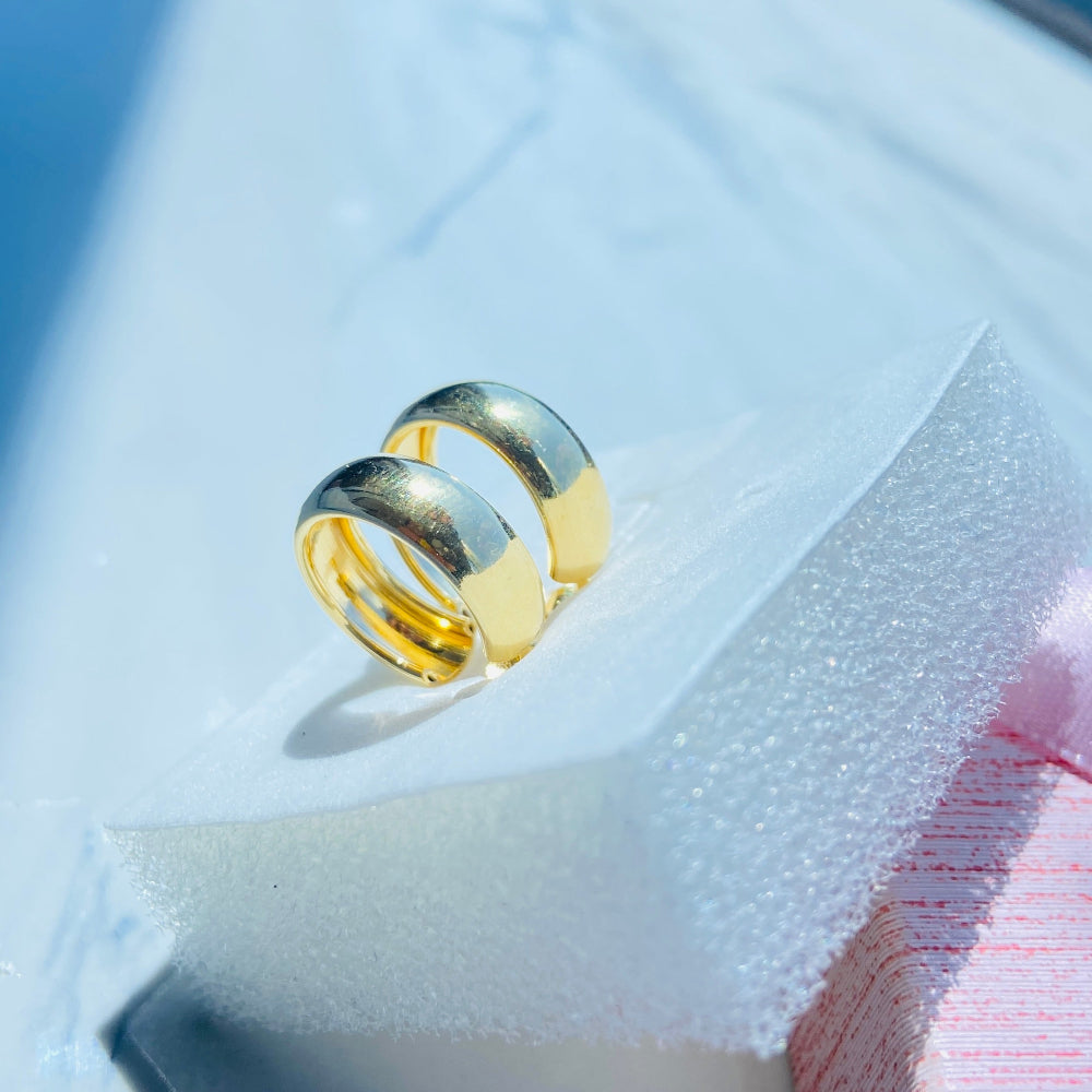 Gold ring on a white surface with a blue background thick gold sleeper hoop earrings women ladies queens exclusive affordable luxury Deep Shine Jewellers jewellery jewelry gold plated 925 silver sterling silver Your Time To Shine DSJ craftsmanship trending shop now