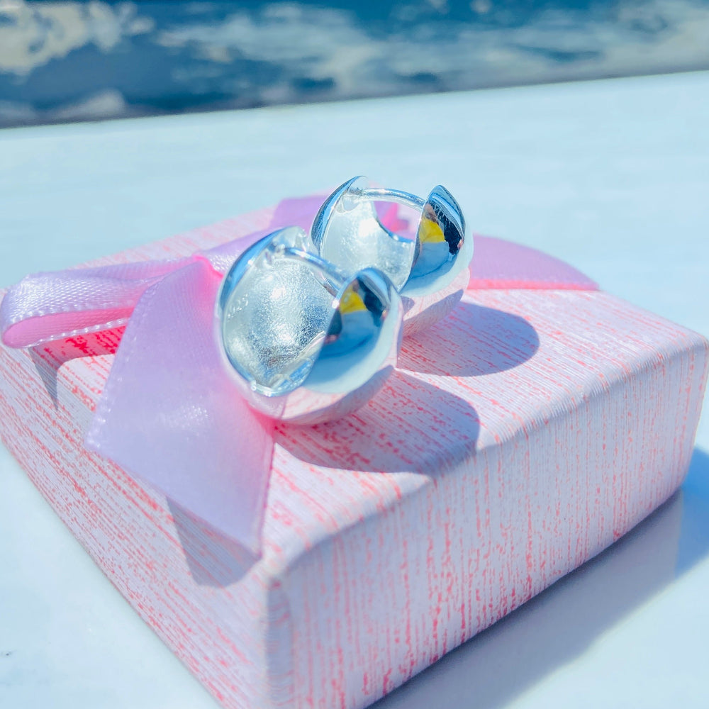 Silver earrings on a white surface with a blurred background silver dome earrings women ladies queens 925 silver sterling silver craftsmanship exclusive Deep Shine Jewellers jewellery jewelry Your Time To Shine elegant shop now trending