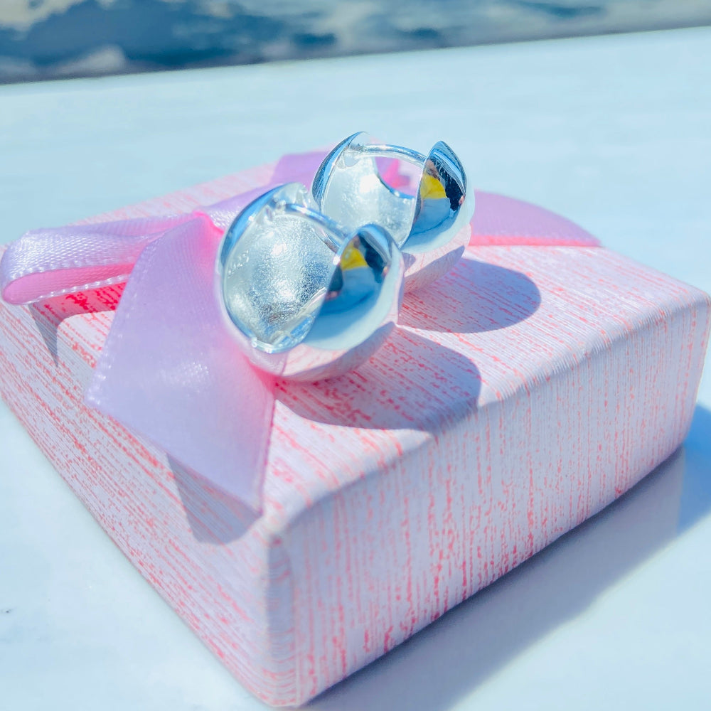Silver sunglasses on a pink box with a blue sky background Silver earrings on a white surface with a blurred background silver dome earrings women ladies queens 925 silver sterling silver craftsmanship exclusive Deep Shine Jewellers jewellery jewelry Your Time To Shine elegant shop now trending